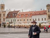 Man in Black Jacket and Black Pants Standing on Sidewalk