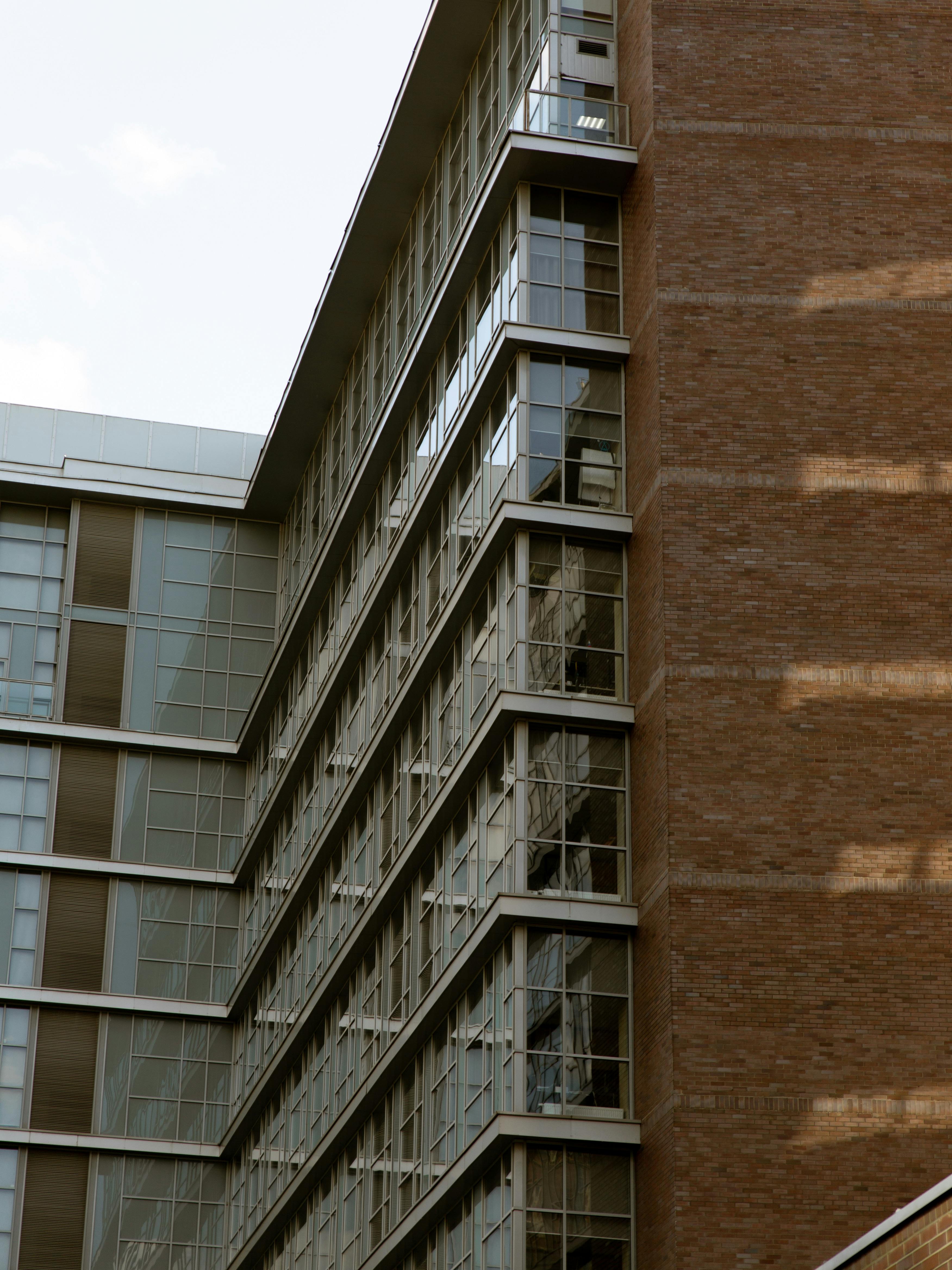 A perspective view of a modern building with glass windows and brick exterior.