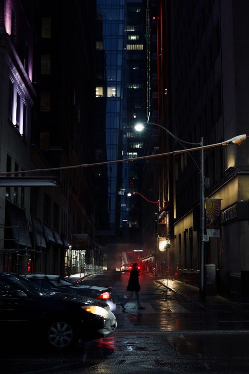 Free Charming wet city night scene with a person walking on a Toronto street, reflecting urban life. Stock Photo