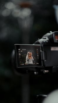 Close-up of camera screen showing a couple during wedding photography outdoors.