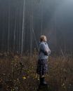 Adult Woman Standing in Forest Clearing in Light of Morning Sun