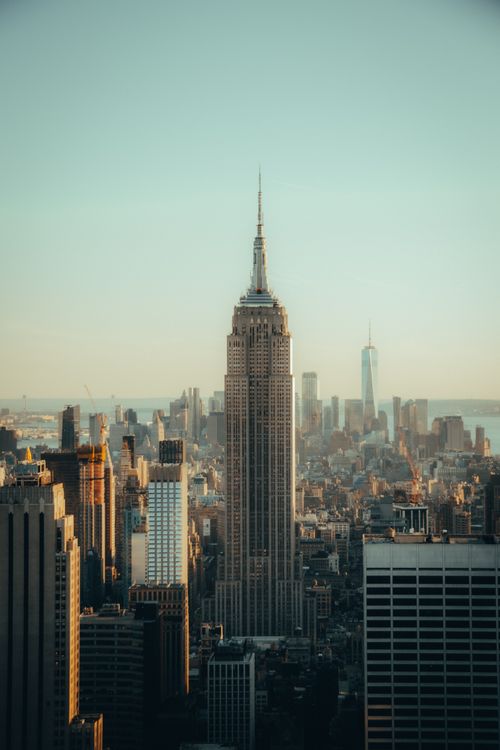 Free Elevated view of the iconic Empire State Building amidst New York City's vibrant skyline at sunset. Stock Photo