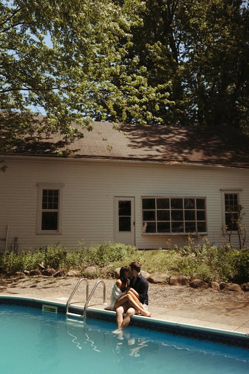 A Couple Sitting near a Swimming Pool