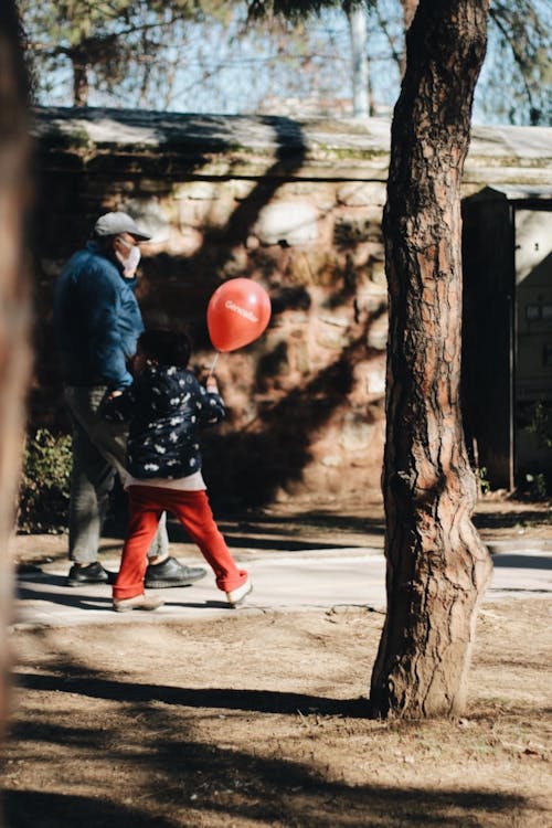 Man Walking with Child with Balloon