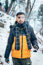 Close-Up Shot of a Man in Winter Jacket and Scarf Smoking
