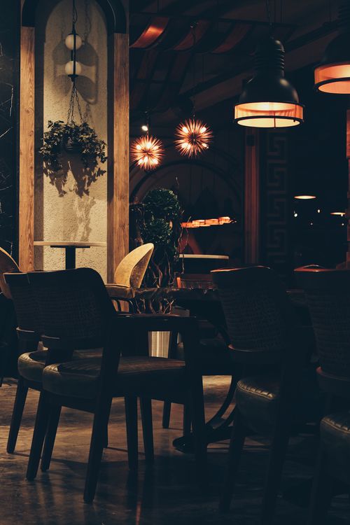 Free Atmospheric café interior with warm lighting and elegant decor creates an inviting ambiance. Stock Photo