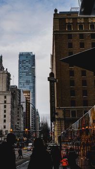 Urban scene in Vancouver featuring Hotel Georgia sign amidst skyscrapers and bustling street life.