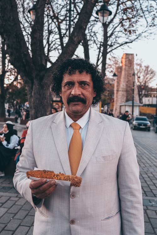 Portrait of Man in Jacket Holding Snack