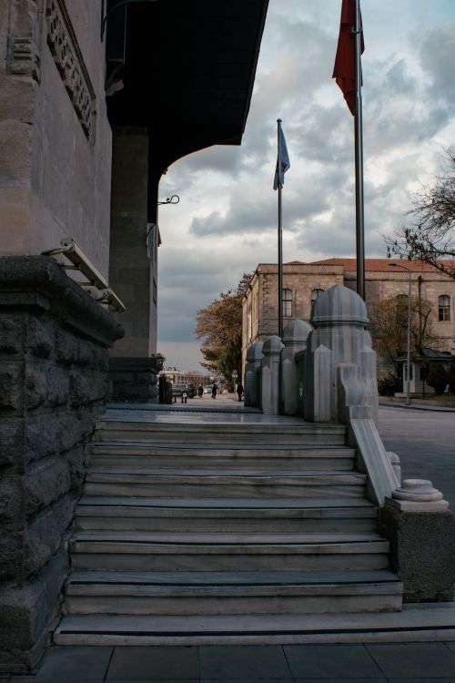 Free Marble staircase with flag poles in front of historic building under a cloudy sky. Stock Photo