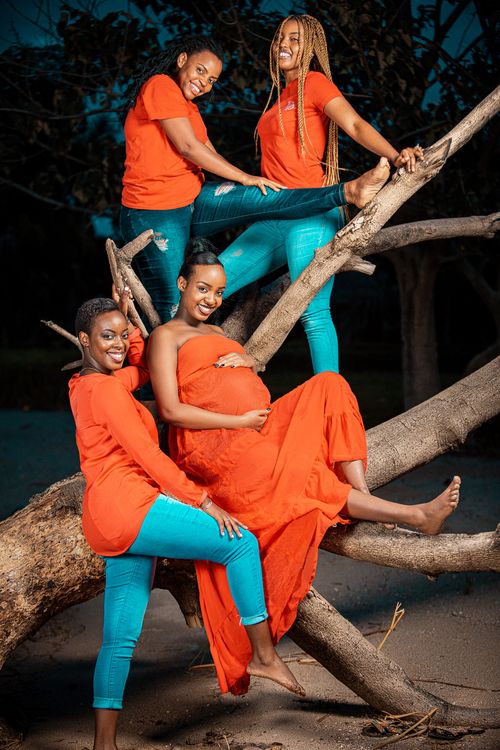 Free Four African American women enjoying a photoshoot in nature, celebrating friendship and pregnancy. Stock Photo