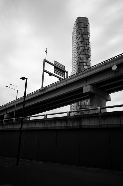 Free A striking cityscape showcasing a modern overpass and skyscraper in black and white. Stock Photo
