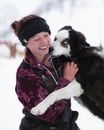 Woman in Red and White Floral Scarf Holding White and Black Siberian Husky
