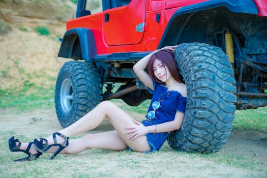 在台北市，一名年轻女子站在一辆红色吉普车旁摆姿势