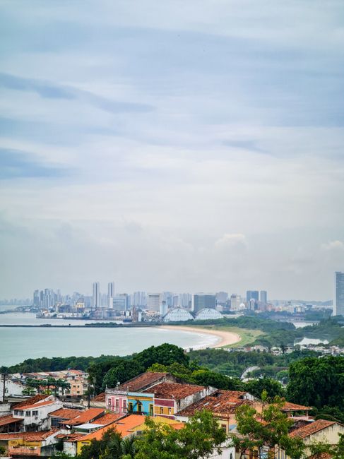 Elevated view of the cityscape of Olinda with Recife's skyline in the background along the coast.
