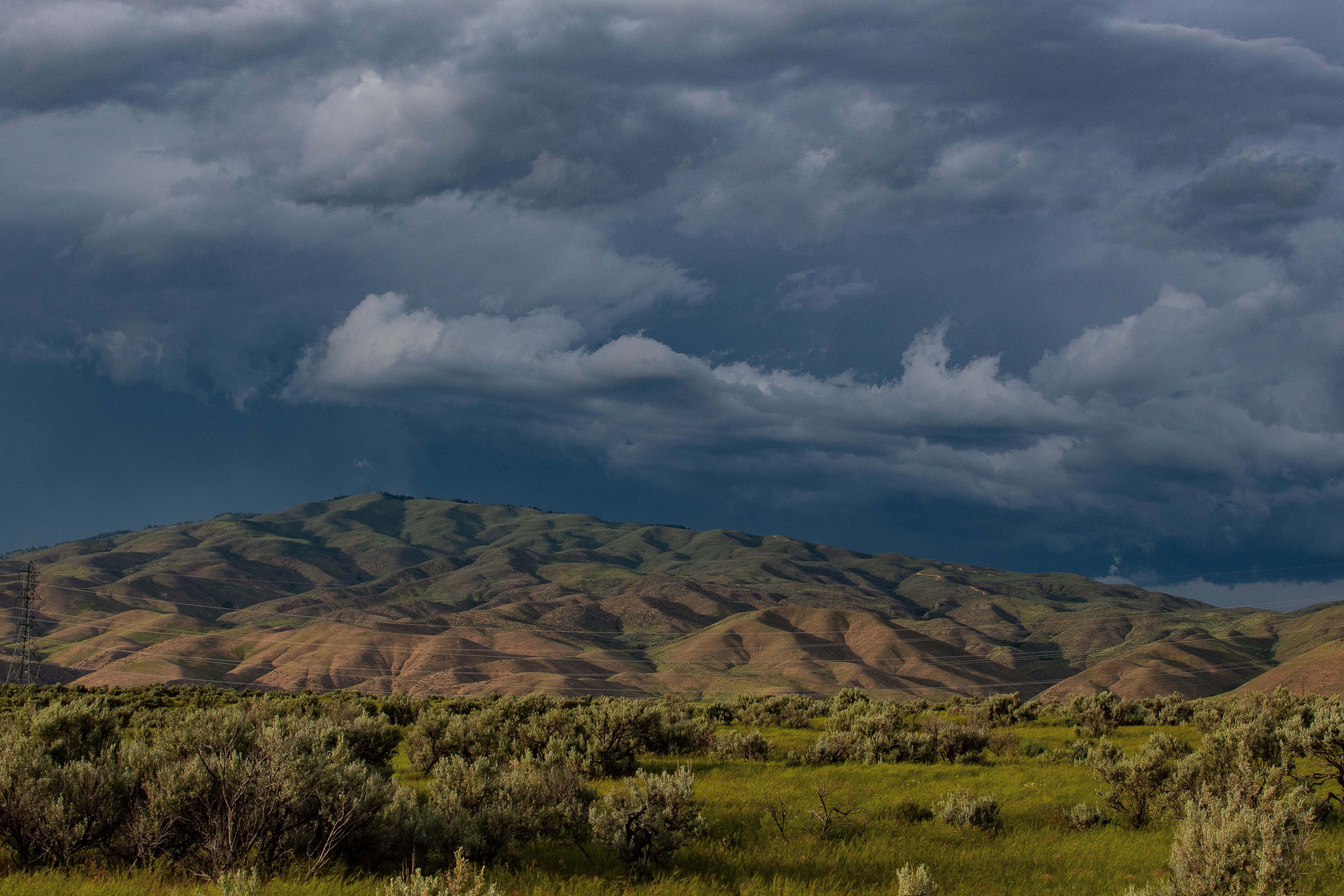 Green and Brown Hills Under Gray Clouds · Free Stock Photo