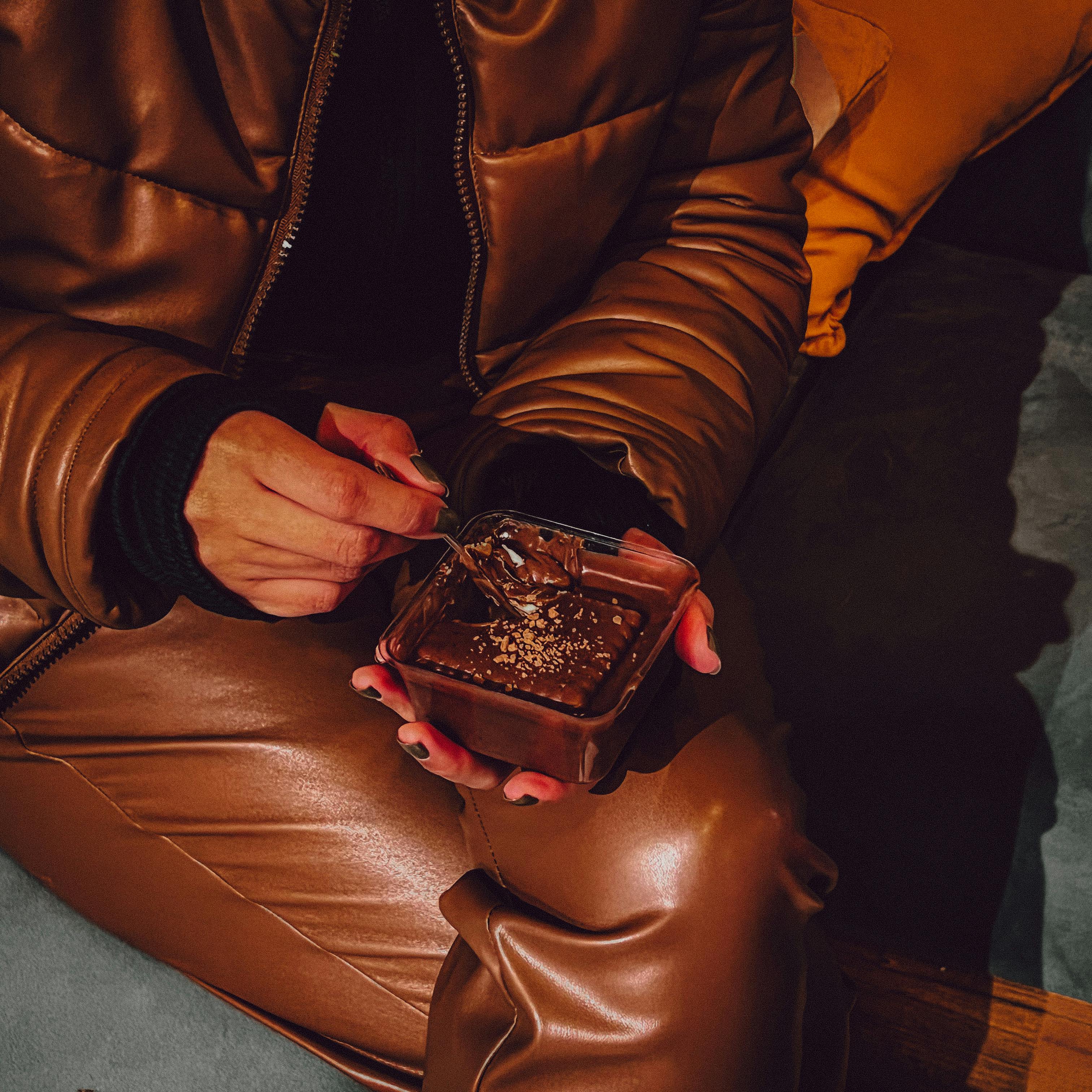 Person enjoying chocolate dessert in a cozy, warm setting, perfect for indulgence.