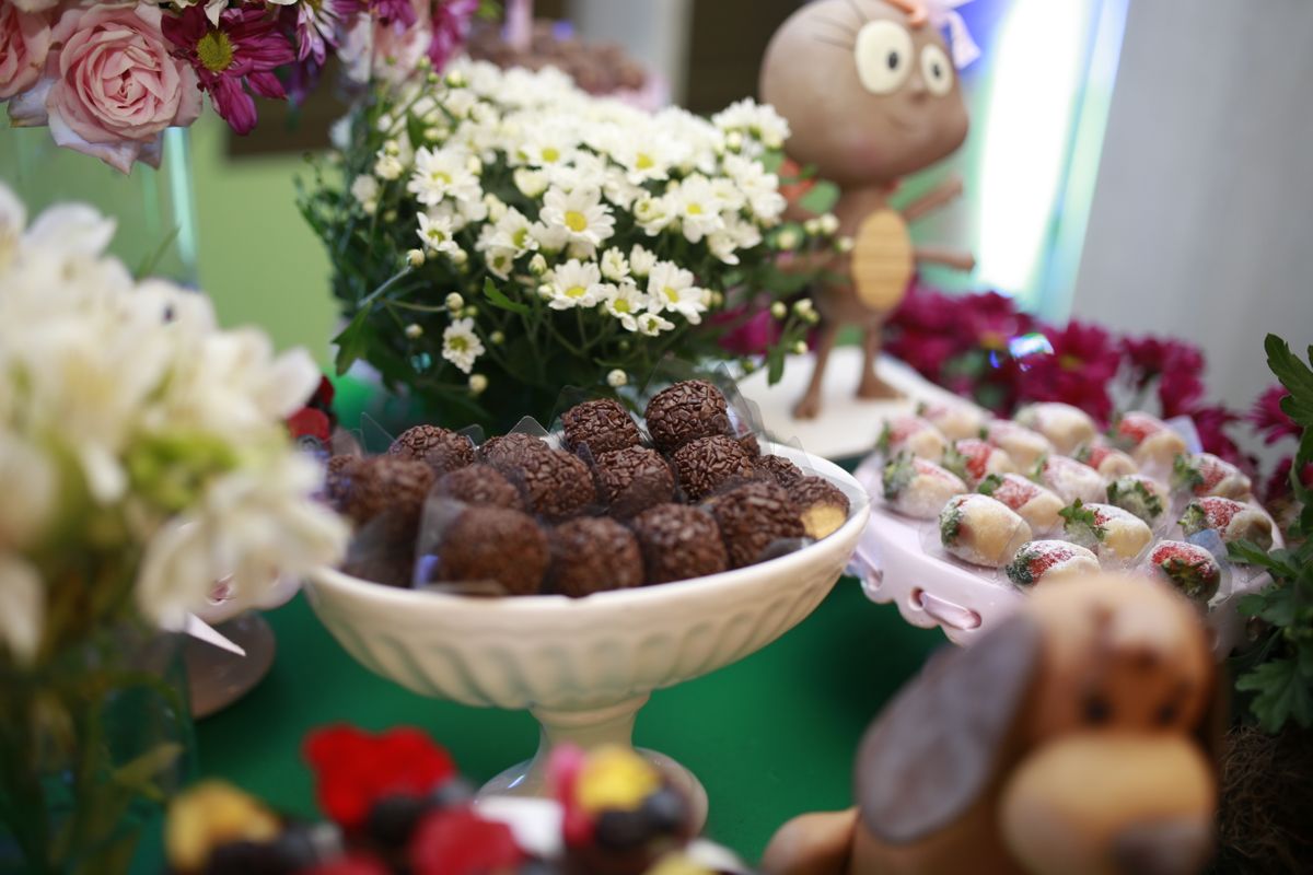 Charming still life of a dessert table with assorted sweets and floral decorations, perfect for celebrations.