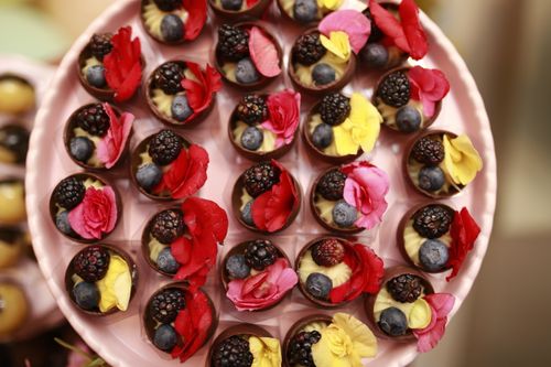 Free Top view of chocolate desserts with berries and edible flowers, perfect for gourmet presentations. Stock Photo
