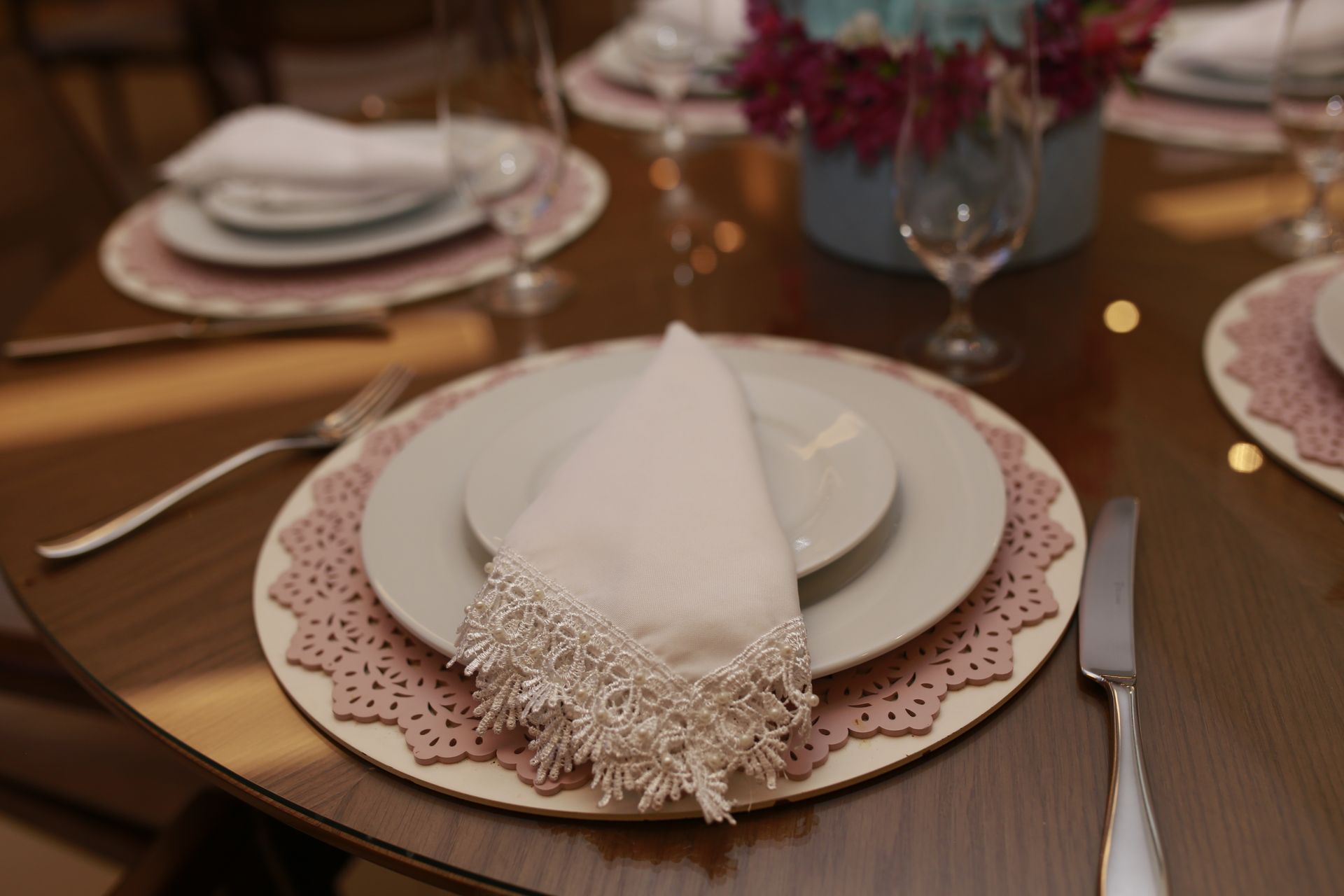 Elegant table setting with lace napkin and floral centerpiece for a fine dining experience.
