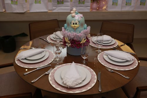 Plates on Table with Toy Bird Decoration