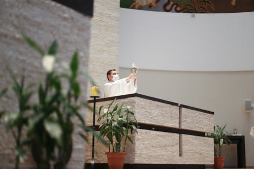 Priest Praying at Service in Church