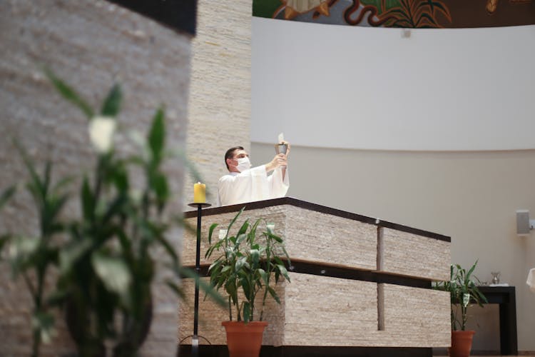 Priest Praying At Service In Church