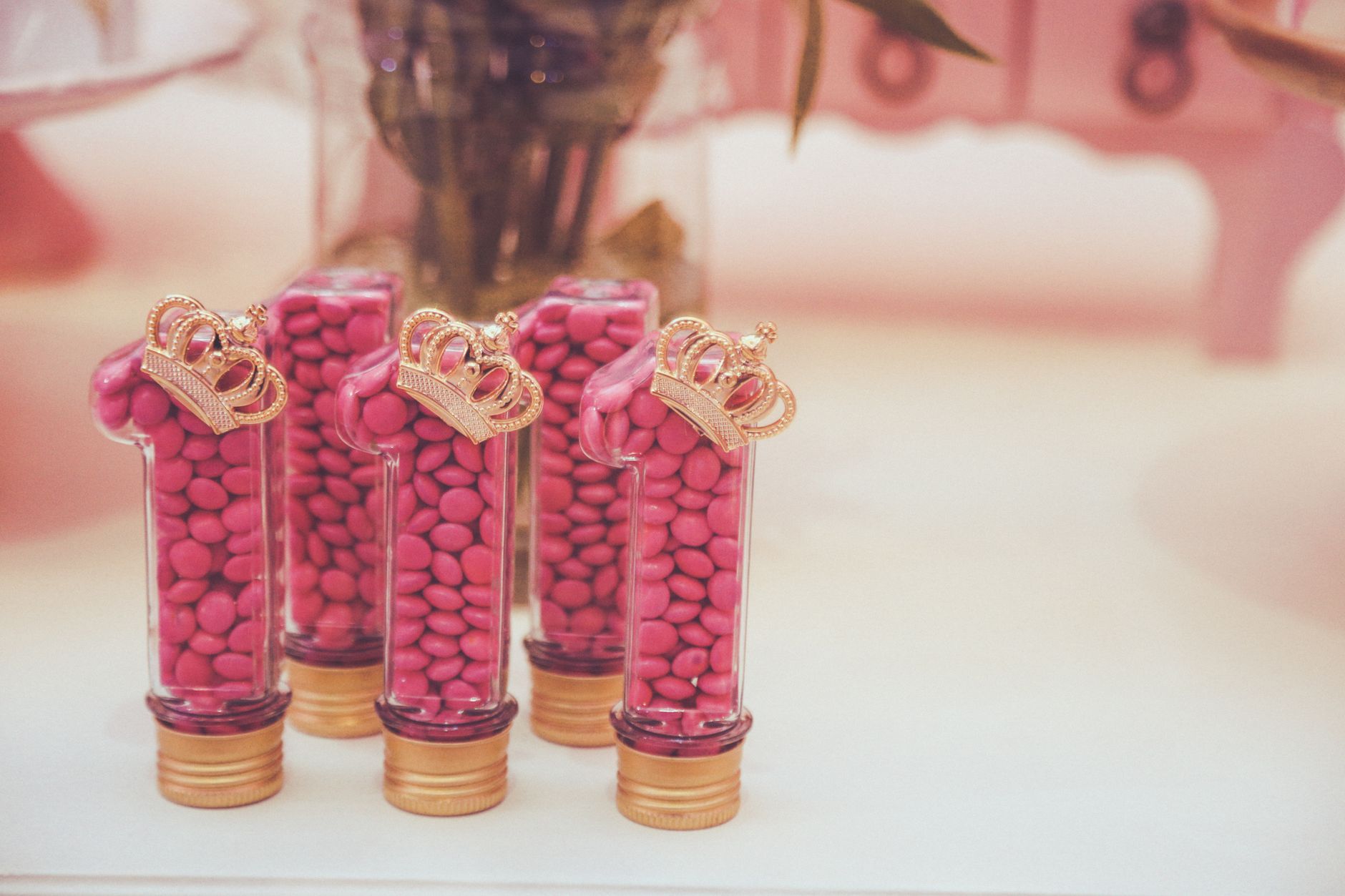 Elegant pink candy containers with gold crown decorations, perfect for parties.