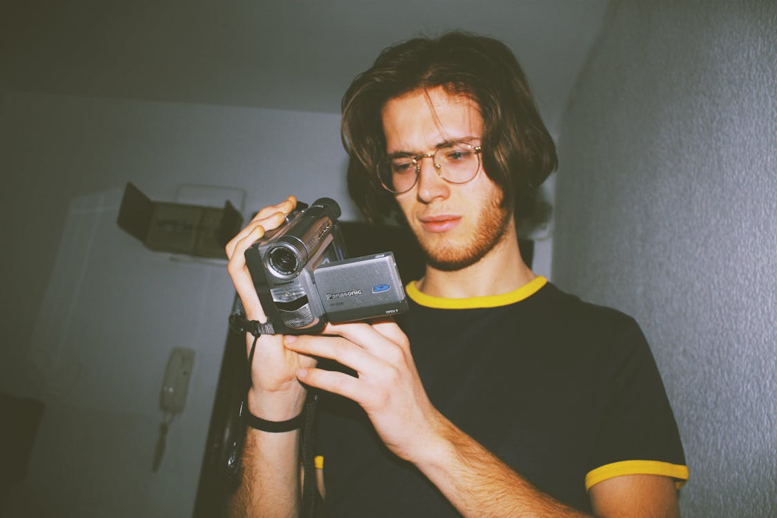 Man Wearing Black Shirt Holding Digital Camcorder