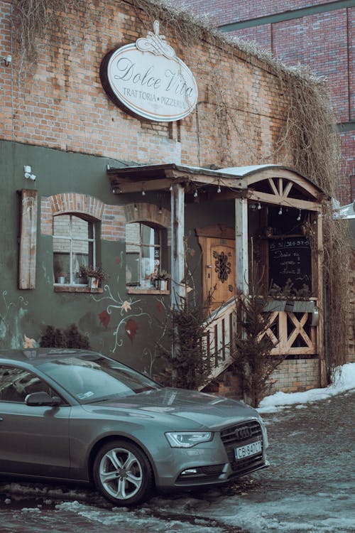 Black Sedan Parked Beside Brown Concrete Building