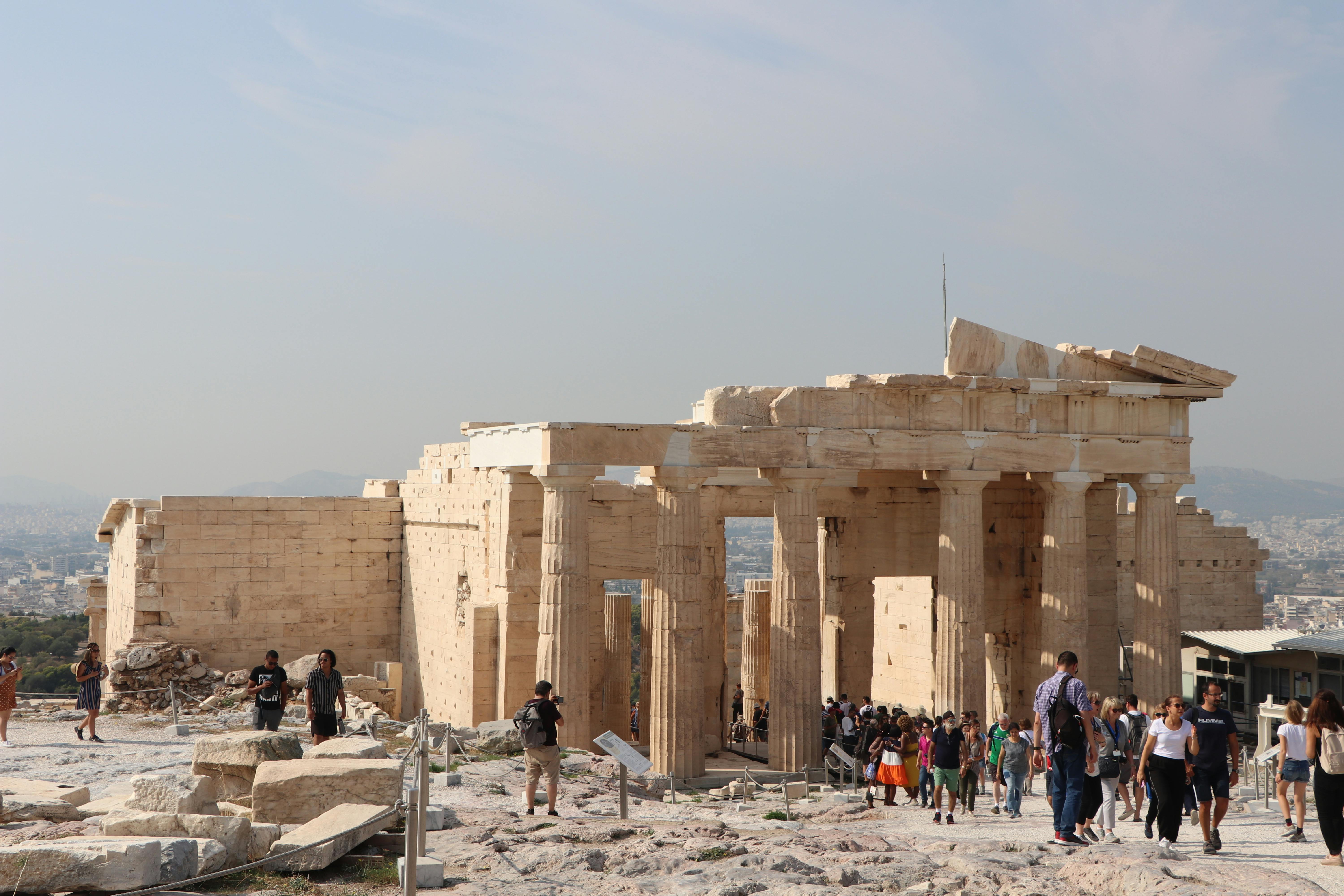 Visitors exploring the historic Propylaea in Athens, a classical Greek architectural marvel.