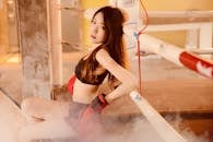 一名年轻女子在拳击场上戴着手套休息，浑身散发着力量和专注