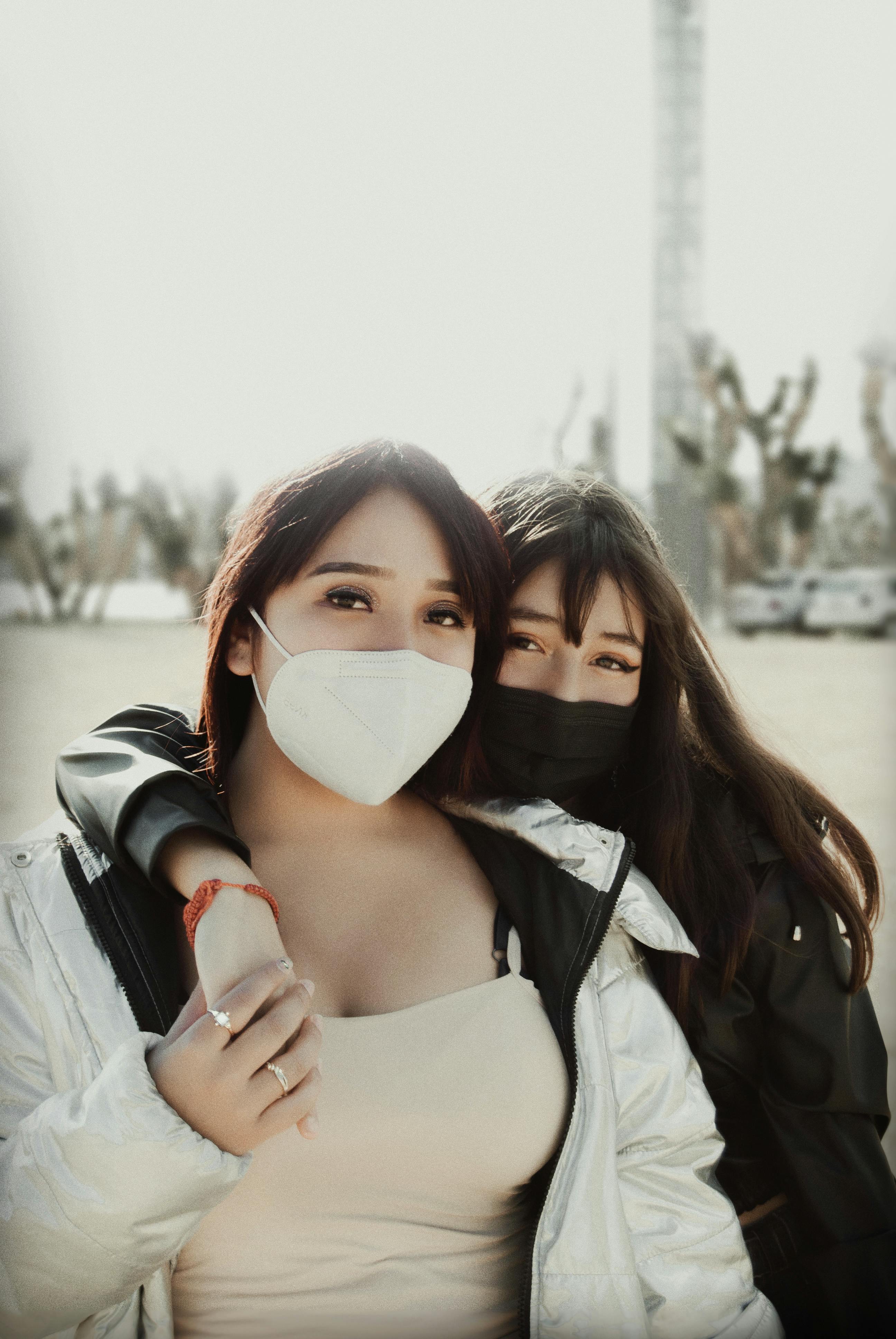 close up photo of female friends wearing face mask