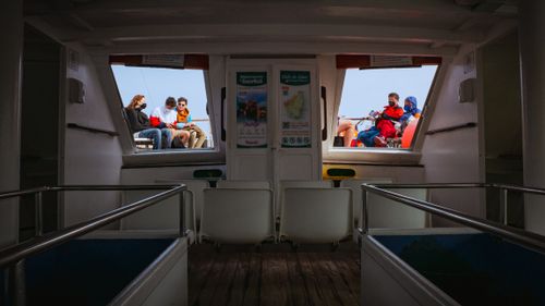 Free Passengers enjoying a scenic boat trip on a sunny day in Spain. Stock Photo