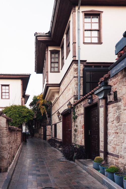Free Picturesque alley showcasing traditional stone buildings and pedestrian walkway in historic urban setting. Stock Photo
