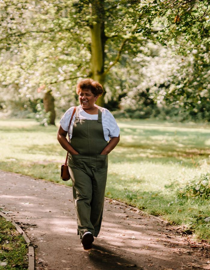 Mujer feliz y vital caminando en un parque
