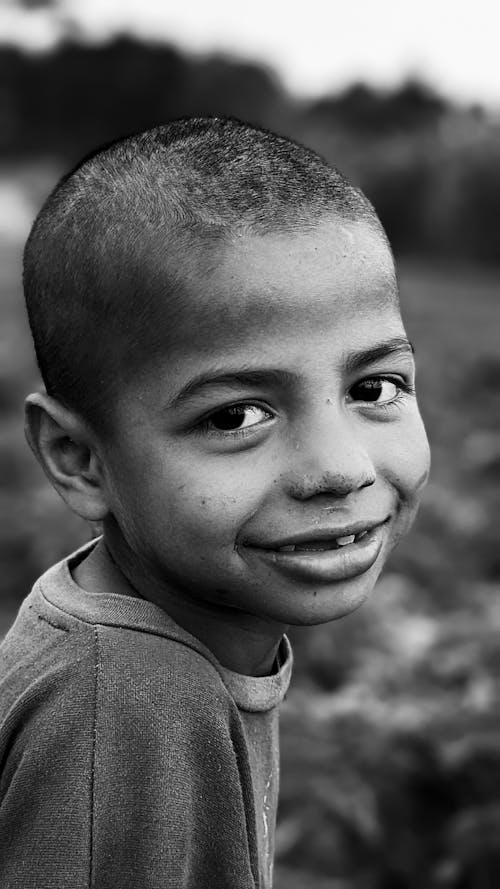 Grayscale Photo of a Smiling Boy 