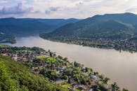 从令人惊叹的鸟瞰图中可以看到，一座小镇坐落在河流旁，四周环绕着郁郁葱葱的山脉