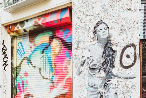 Stencil Art Of Woman On Wall Near Door Shutter With Graffiti