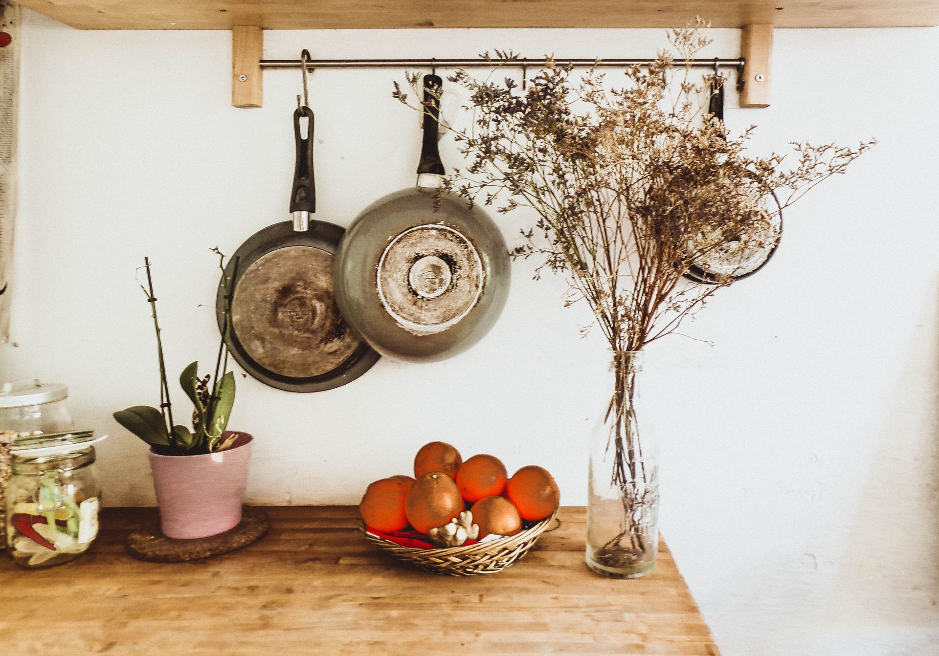 A cozy, rustic kitchen setup with hanging pans and wooden decor in an organized interior space.