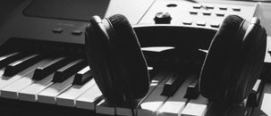 Black Wireless Headphones on Gray Electronic Keyboard