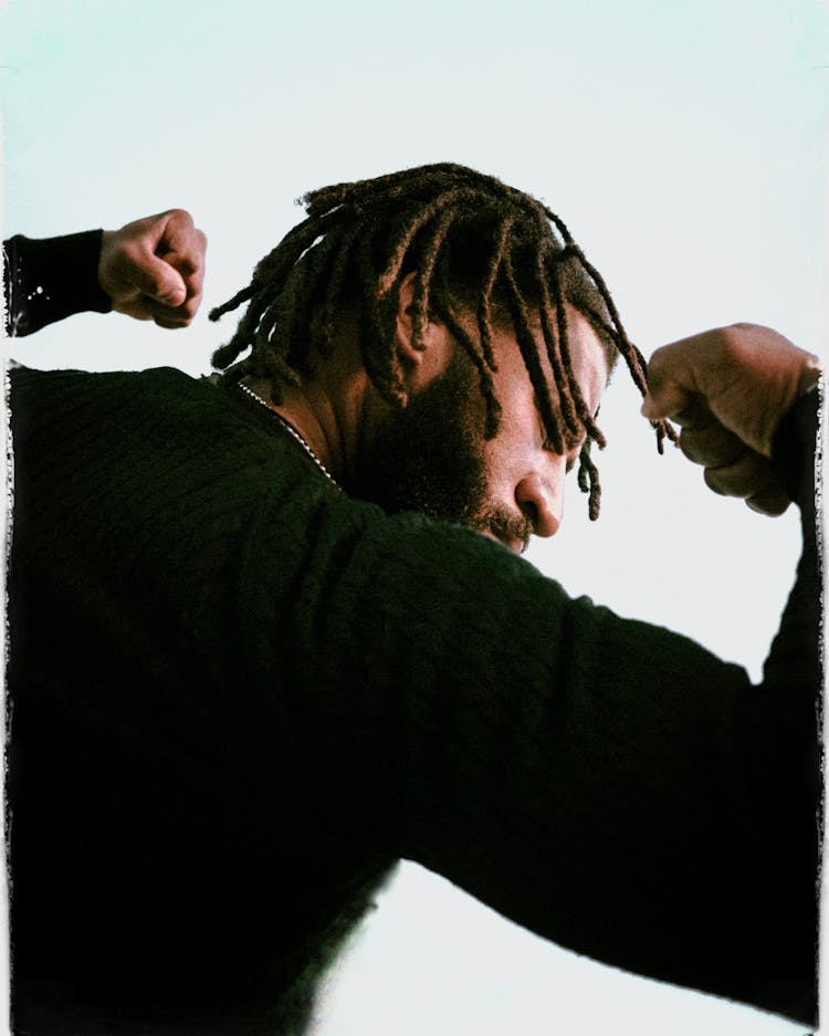 A Bearded Man In Black Sweater Flexing His Arms