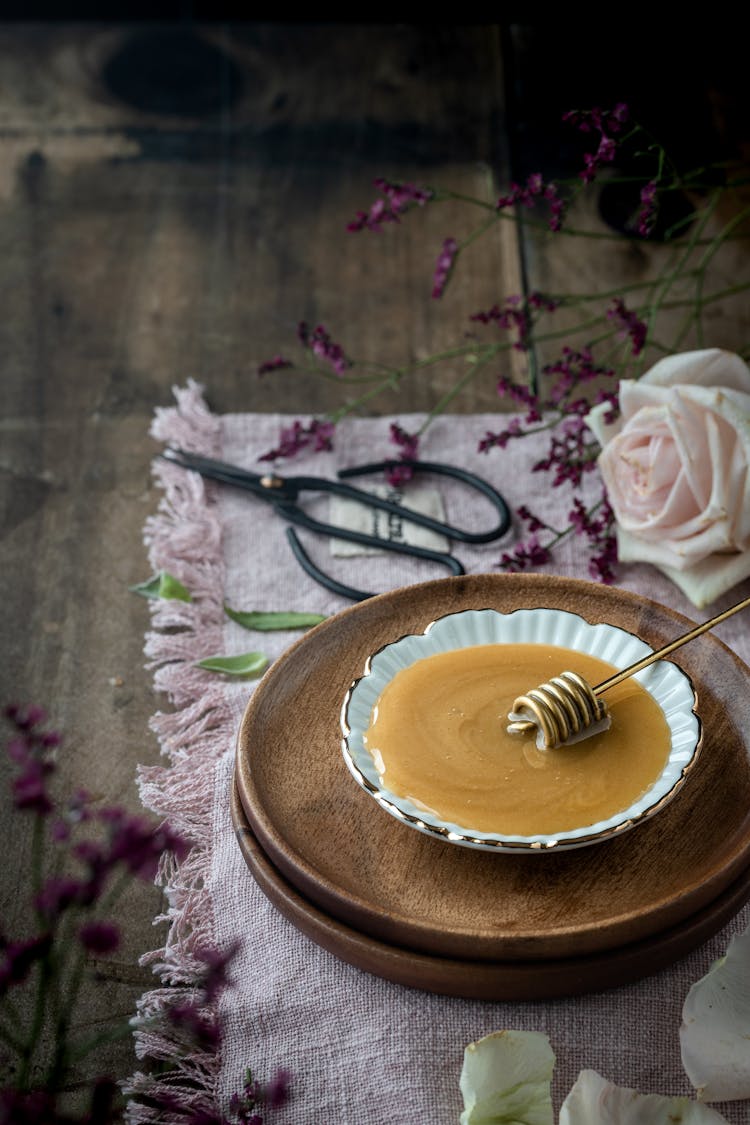 Photo Of A Honey Dipper On A Saucer