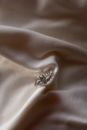 Silver Diamond Ring on White Textile