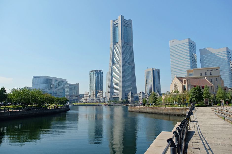 View of modern skyscrapers and serene waterfront in Yokohama, showcasing urban architecture.