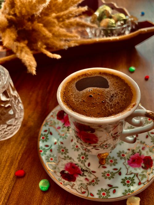 Free Aromatic Turkish coffee served in a floral patterned cup with colorful sweets. Stock Photo