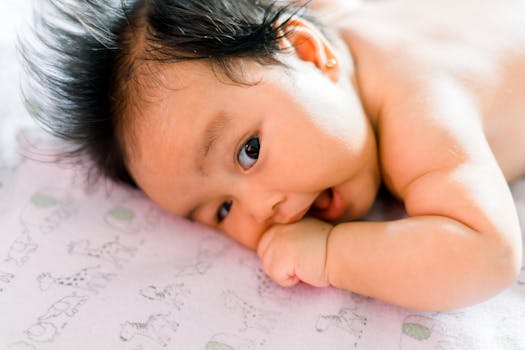 Close-up of a cute baby lying and sucking their thumb on a patterned blanket.