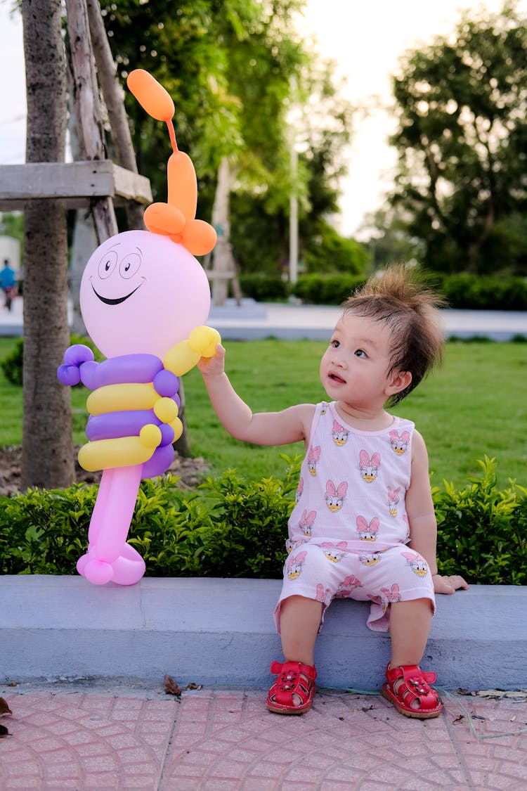 Toddler Holding A Toy Balloon