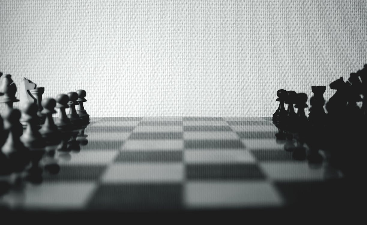 무료 흰 벽 근처 흑인과 백인 체스 판 세트 스톡 사진