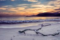 Body of Water Near Mountain Under Gray Sky at Golden Hour