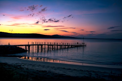 бесплатная Силуэт морского дока на водоеме во время заката Стоковое фото